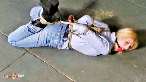 Blonde woman bound in ropes and gagged, lying on floor in jeans from INSEX Cowtest remastered
