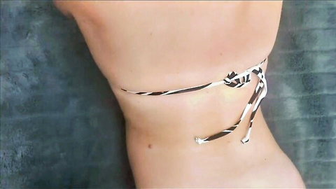 Sexy girl's round ass in zebra striped bikini thong bottoms from behind poolside