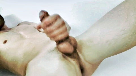 Muscular man in shower jerking off, close-up of hard cock and balls