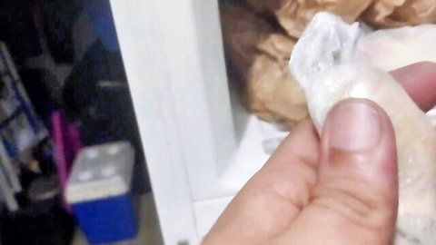 Hand holding peeled ginger root for first-time figging anal insertion in lesbian BDSM session