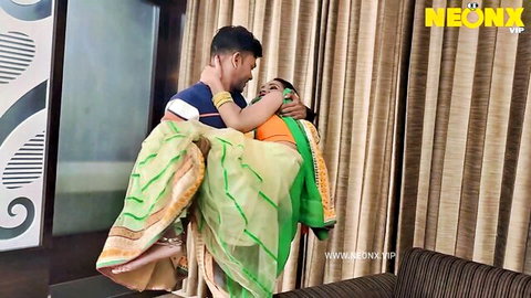 Indian man passionately lifts beautiful saree-clad woman in intimate embrace