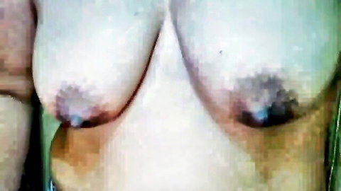 Close-up of big pale tits with dark puffy nipples fully exposed on webcam.