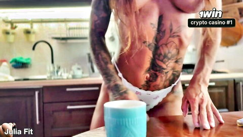 Busty tattooed blonde bends over kitchen table in white panties exposing tight ass and big tits