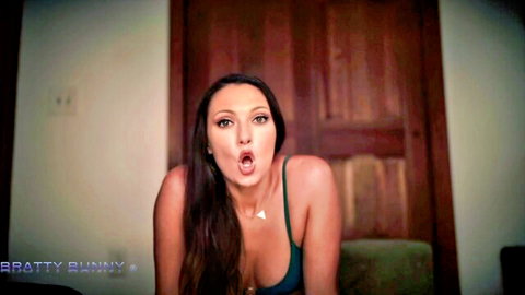 Brunette babe with huge cleavage makes sexy open mouth O face in tight green top