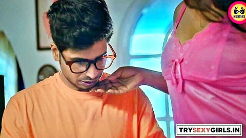 Indian couple in intimate foreplay, woman in pink lingerie touches man's chest