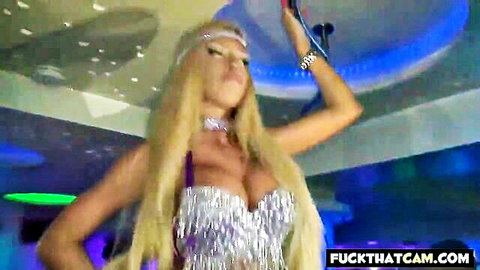 Blonde big tits stripper dances seductively holding mic in sparkly fringe top at neon club