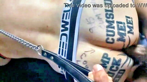 Tattooed male cumdump in blue underwear with leash and explicit genital exposure