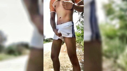 Thai guy shirtless in Adidas shorts, wanking outdoors with athletic abs