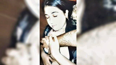 Blurry close-up of brunette woman embraced by man's hairy arm