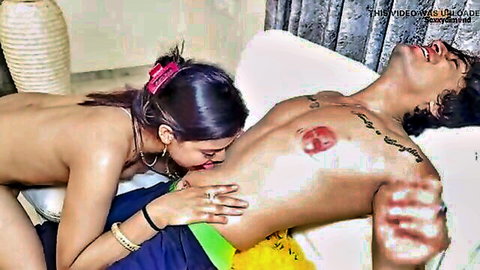 Indian woman passionately kissing nude man's tattooed chest in steamy foreplay