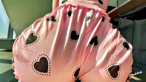 Curvy brunette in pink heart-patterned shorts, bending over to tease big ass