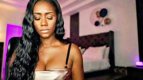 Stunning ebony babe with huge cleavage in shiny low-cut top teasing solo in bedroom webcam