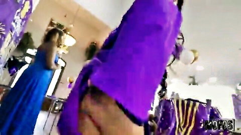 Diabella Eclair in revealing purple dress, bending over at party with friend in blue gown