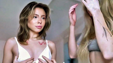 Brunette babe squeezing her big tits in white bra while blonde poses behind
