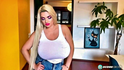 Busty blonde Kitty Cute posing in tight white tank top and jeans