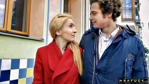 Blonde in red coat eyes curly-haired man on street casting
