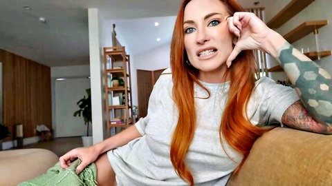 Tattooed redhead Jakknife in gray tee, intense expression teasing