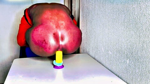 Aden Victorea with massive red ass bent over table, yellow toy tease