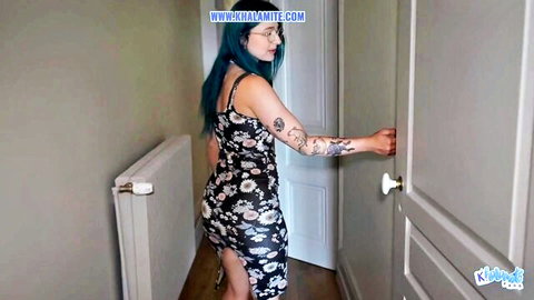 Teal-haired tattooed French alt woman in floral dress opening door teasingly