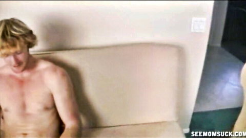 Blonde young stud with big hard cock sits on couch stroking his thick dick