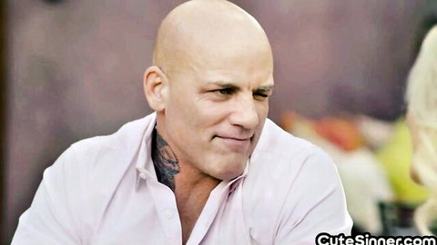 Bald tattooed man smiles with busty blonde babe in romantic pre-sex date scene