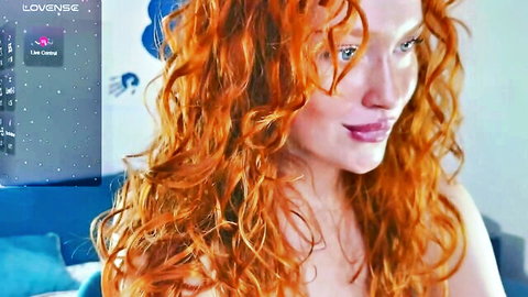 Sexy redhead with curly hair smiles seductively on live webcam closeup