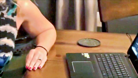 Mature woman in striped top with red nails, teasing near laptop