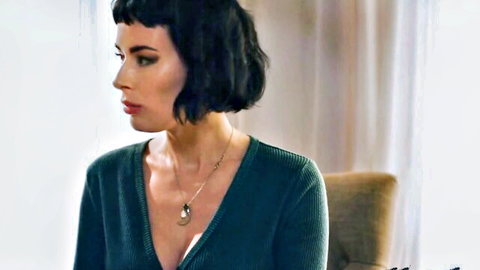 Olive in seductive green v-neck sweater, profile view