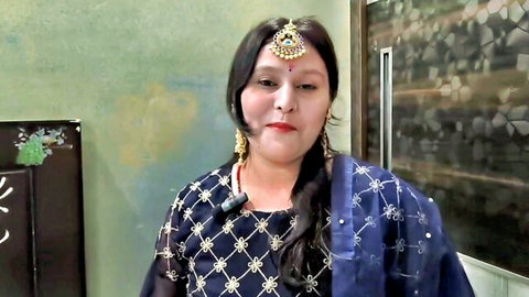 Curvy Indian BBW in embroidered blue saree smiling seductively with big tits cleavage