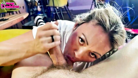 Blonde woman sucking thick cock with hand gripping base in intense close-up blowjob