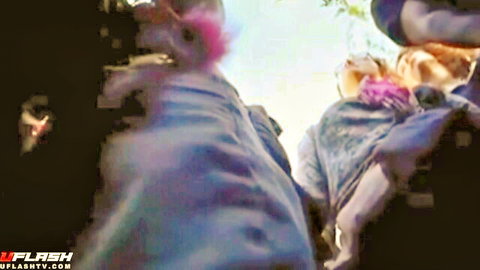 Blurry outdoor fun groping scene with colorful dressed women and pink hair