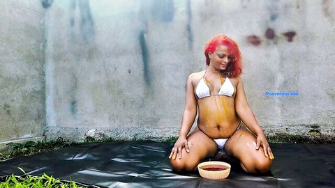 Poornima in white bikini kneeling with bowl, red hair seductress