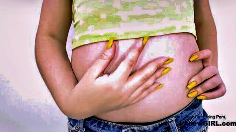 Young pregnant cutie pie touching belly in crop top and jeans