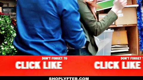 Couple in store aisle with Christmas decor, woman in green jacket caught shoplifting vibe