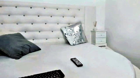Empty luxurious white round bed in webcam bedroom setup with pillows and nightstand for solo female masturbation