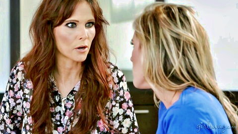Redhead and blonde women in tempting conversation, floral blouse and blue top