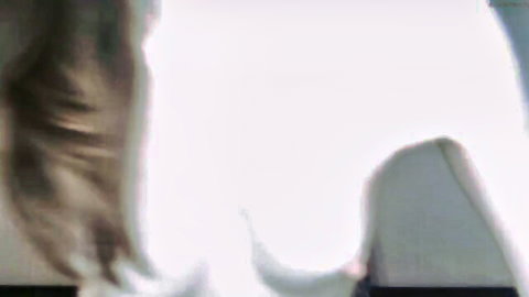 Blurry brunette webcam girl with long flowing hair in white top teasing viewers