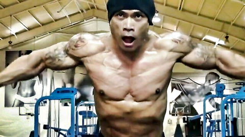 Muscular Asian bodybuilder flexing huge biceps in gym pose