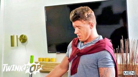 Muscular tattooed man in gray shirt and red scarf, teasing in trans gay scene