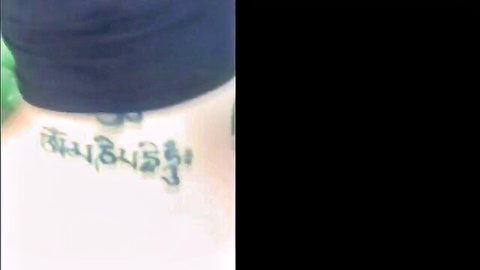 Ebony girl's sexy Thai script tramp stamp tattoo above plump ass cheeks