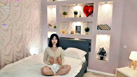 Queendutter shy Asian camgirl in white top and shorts, sitting on bed