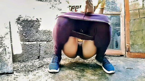 Amateur woman squatting to pee outdoors in pulled-down purple leggings, exposing ass and pussy
