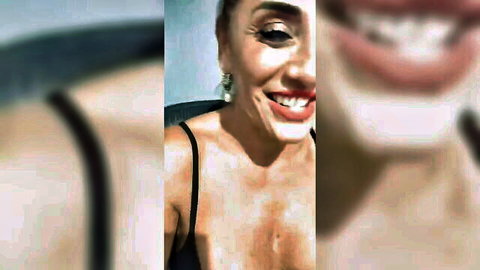 Smiling mature Italian MILF in black spaghetti strap top showing cleavage