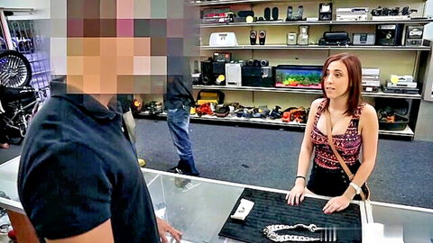 Redhead in tank top negotiates at pawn shop counter with customer