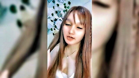 Asian girl with long braided hair and cleavage in low-cut top