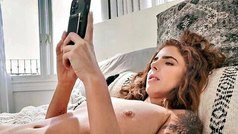 Topless tattooed redhead takes seductive selfie exposing perky natural tits on bed