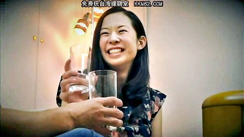 Smiling Japanese woman in floral dress cheers water glass with man's hand in apartment