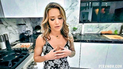 Blonde MILF stepmom in floral dress clutching hands over big tits in kitchen
