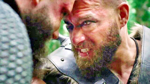 Two intense bearded Viking warriors in leather armor face off in forest clash