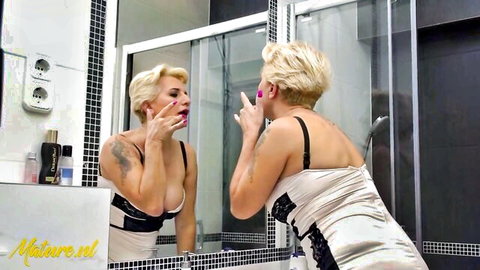 Mature blonde Mirella applies lipstick in sexy satin dress before shower